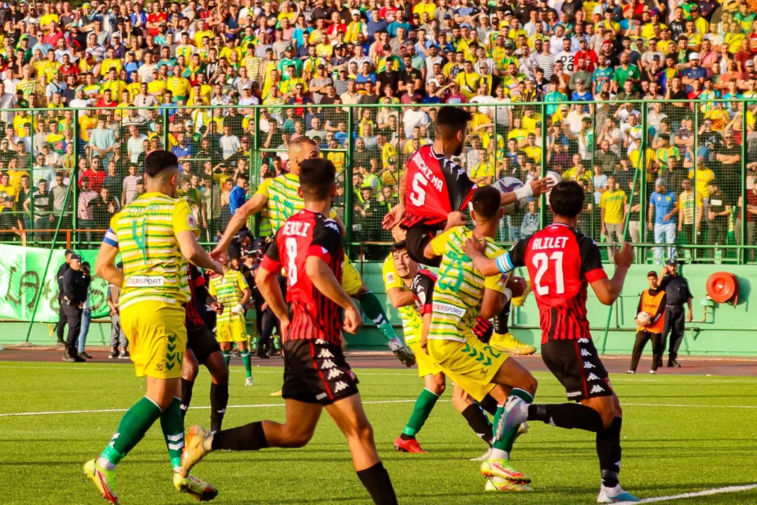 Joueurs de football en action lors d'un match intense en plein air.