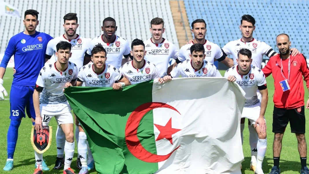 La mauvaise passe continue pour l’USM Alger! La FIFA inflige une nouvelle raclée au club dz Groupe de joueurs de l'USM Alger avec drapeau algérien en fond.