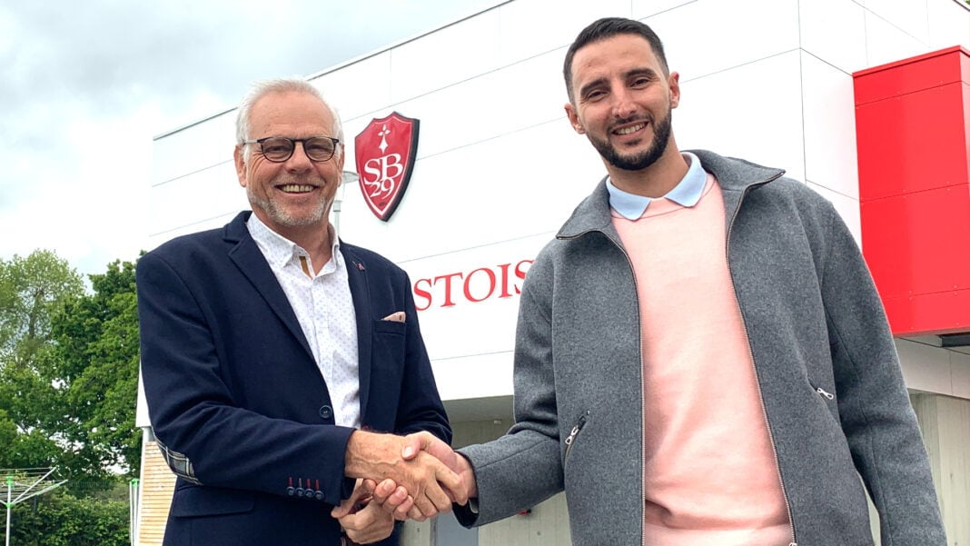 Deux hommes se serrent la main devant le stade Deux hommes souriants se serrent la main devant le stade de Lille.