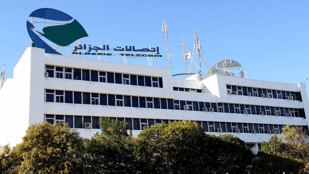 C’est fait ! Algérie Télécom sponsor officiel de l’USMK pour 2024-2025 Bâtiment d'Algérie Télécom avec logo et antennes.