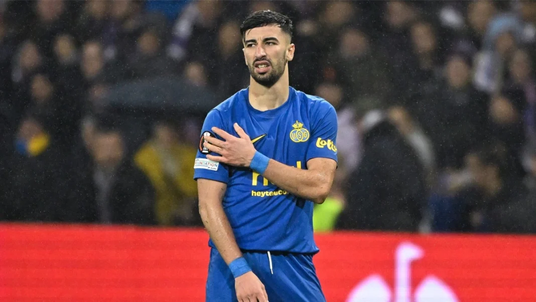 Incertitude autour d’Amine Amoura : Petkovic hésitant, fait durer le suspense Amine Amoura en maillot de football bleu sur le terrain.