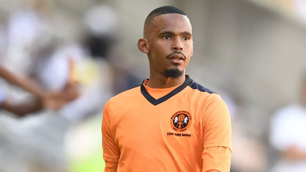 MC Alger : Oswin Appollis en passe de remplacer de Youcef Belaili Oswin Appollis en maillot orange lors d'un match de football.