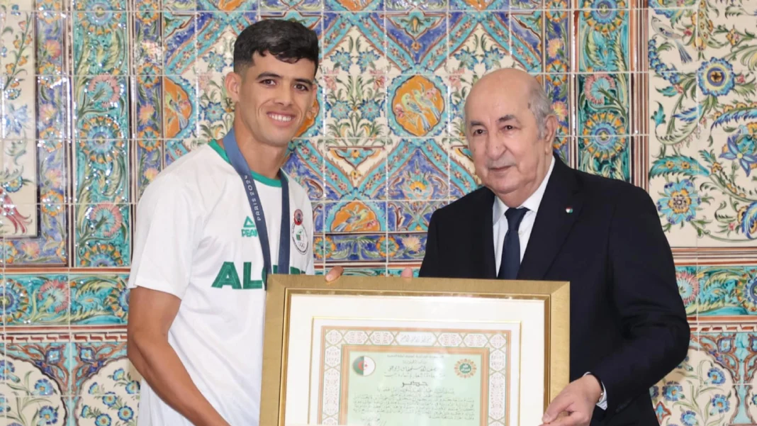 Abdelmadjid Tebboune démontre encore toute sa classe! Les médaillés algériens décorés… Athlète algérien recevant une médaille lors d'une cérémonie officielle.