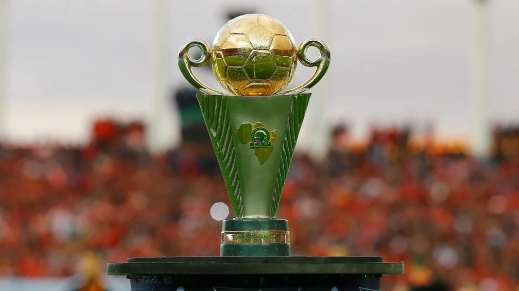 Coupe de la CAF : L’US Touarga du Maroc crie au scandale ! Trophée de la Coupe de la CAF avec un fond de stade rempli de spectateurs.