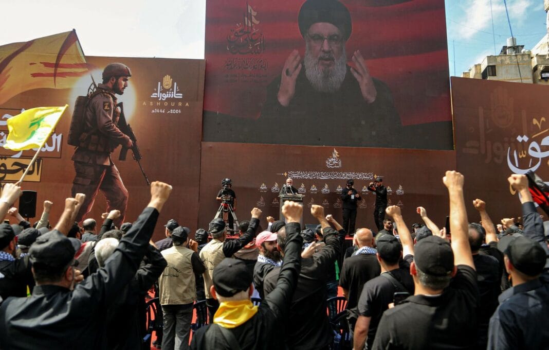 Manifestation populaire avec discours de Nasrallah sur grand écran.