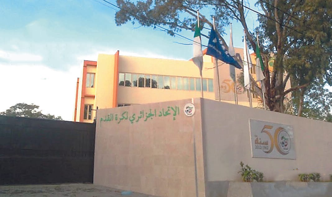 Bâtiment d'une école ou université en Algérie avec drapeaux.