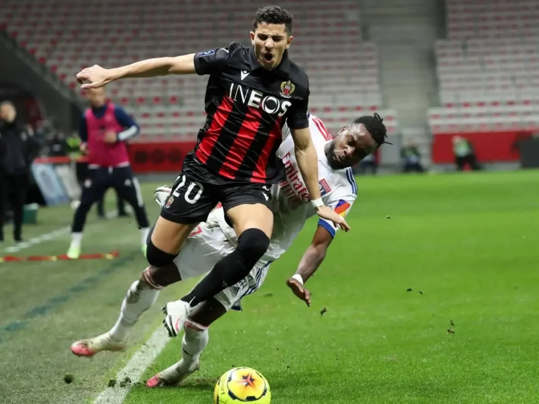 Youcef Atal en duel pour le ballon sur le terrain de football.