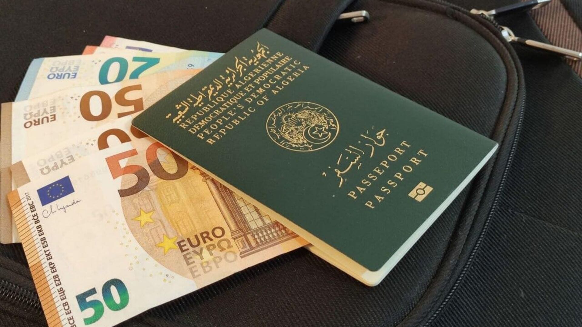 Passeport et argent pour voyager à l’étranger Passeport et billets d’euros sur une valise pour voyager à l’étranger.