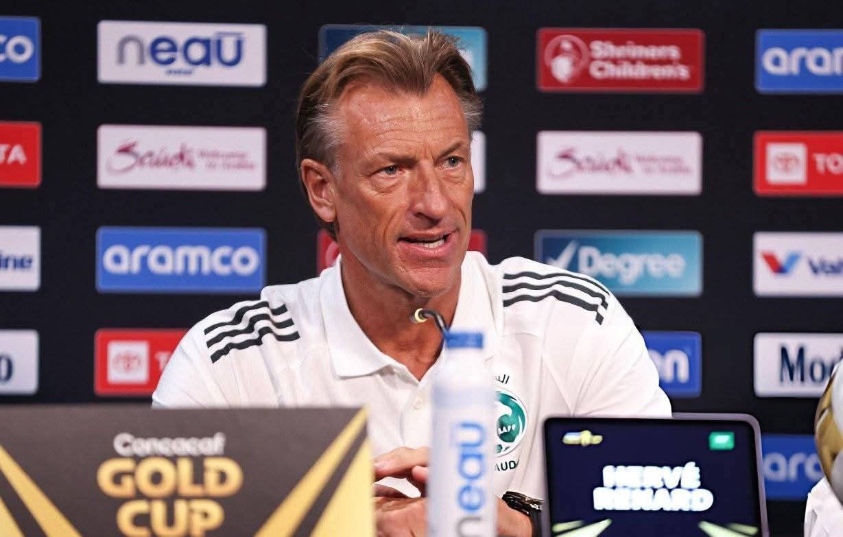 Retour de Renard en Algérie ? Les coulisses révélées Entraîneur de football lors d'une conférence de presse avec sponsors en arrière-plan.