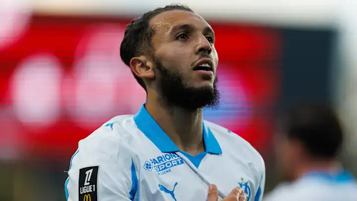Footballeur algérien lors d'un match, concentré et déterminé.
