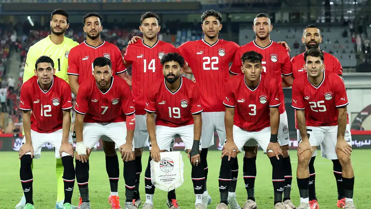 Groupe de joueurs de football en uniforme rouge sur le terrain.