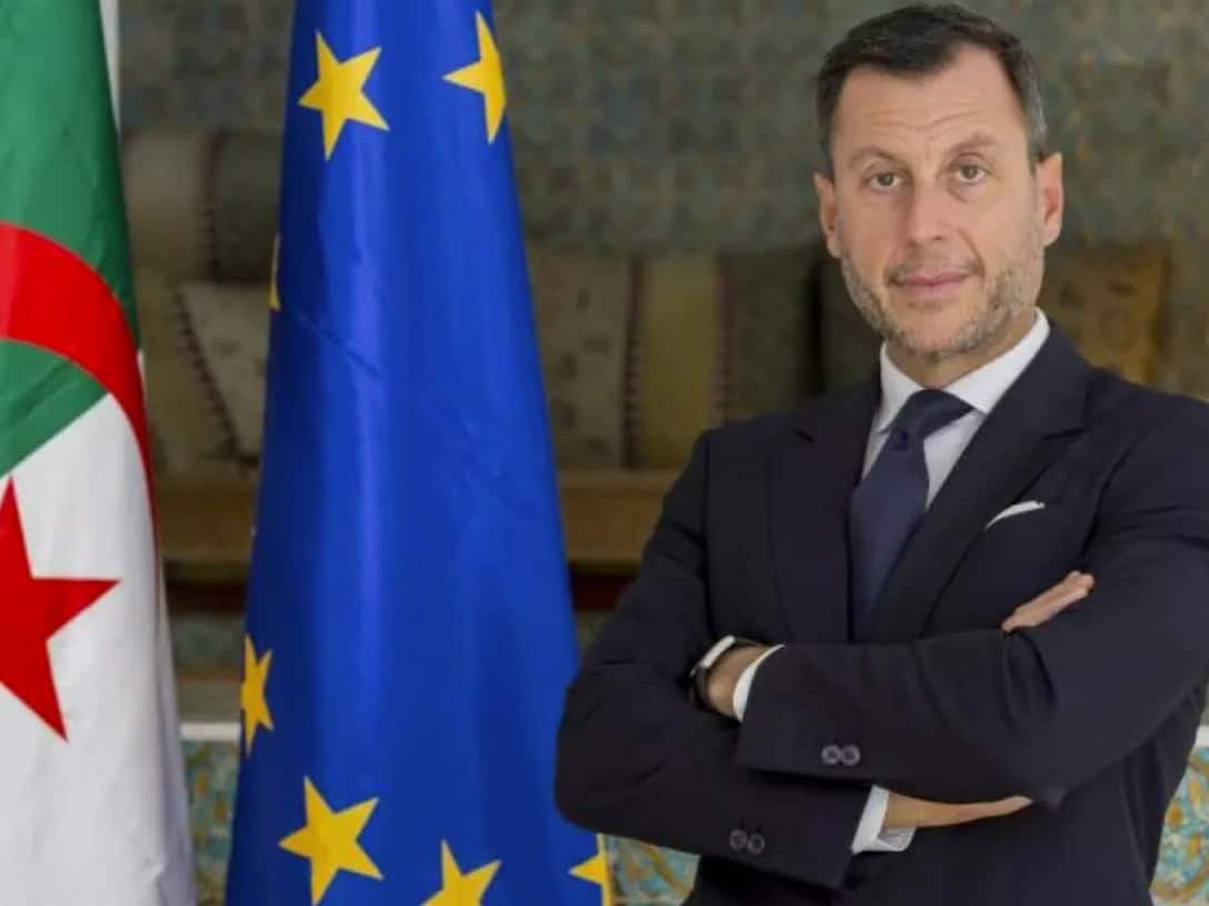 Visa Schengen Algérie : révélations de l’ambassadeur de l’UE Ambassadeur de l'UE en Algérie avec drapeaux européens et algériens.