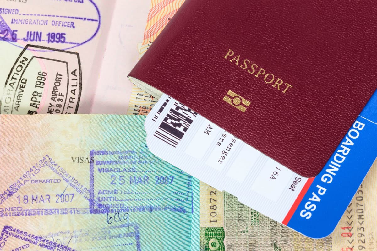 Passeport et documents de voyage Passeport rouge avec billet d'avion et visas sur fond blanc.