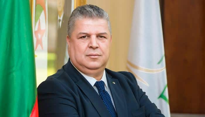 Chute d’Amara Charaf-Eddine : les raisons de son incarcération Homme politique algérien en costume, portrait sérieux.