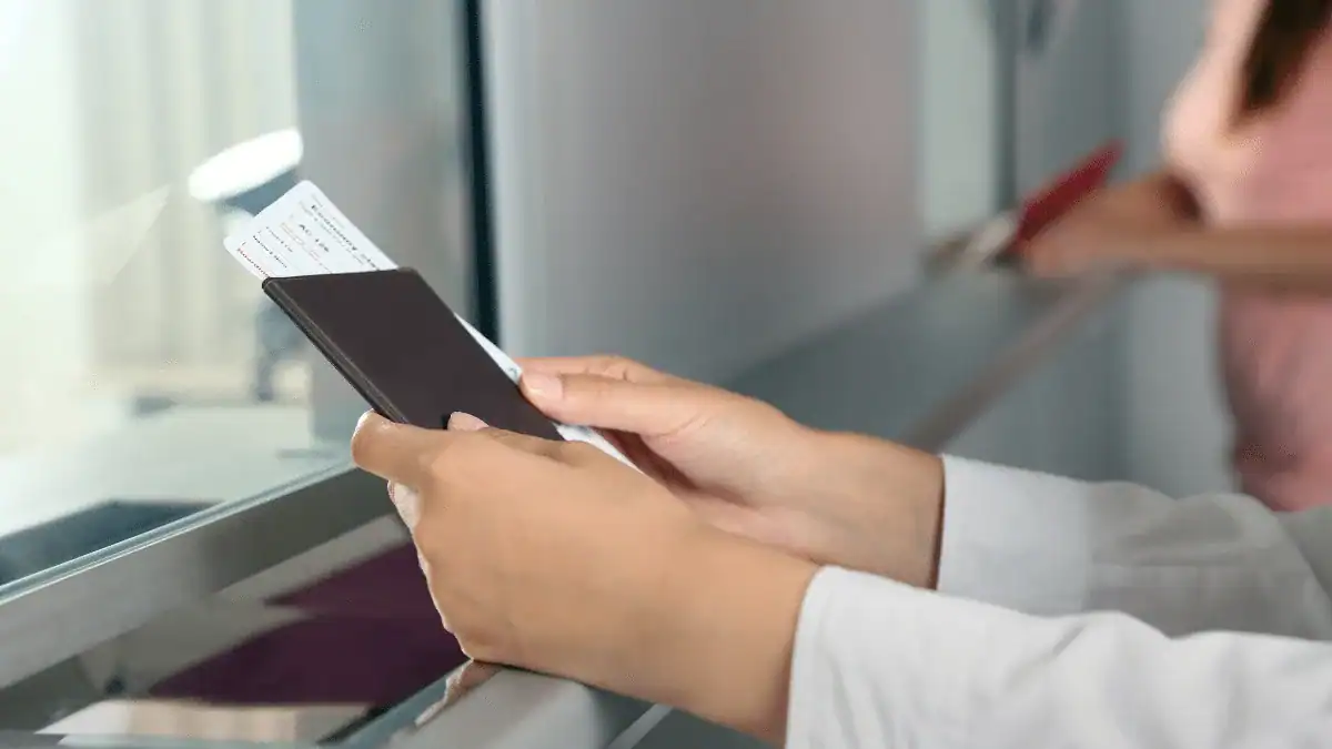3 cas où les binationaux peuvent entrer en Algérie sans visa Personne vérifiant un passeport à l'aéroport.