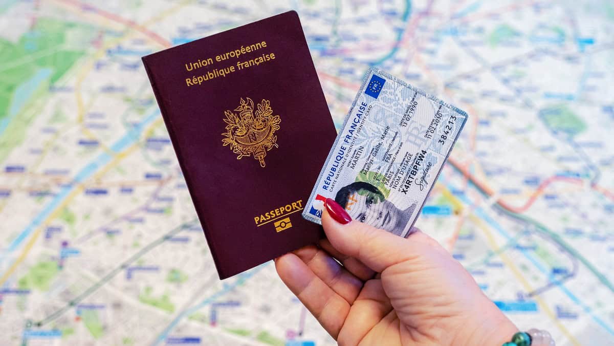Algériens en France : une permanence consulaire à ne pas manquer Passeport européen et visa dans une main sur une carte de Paris.