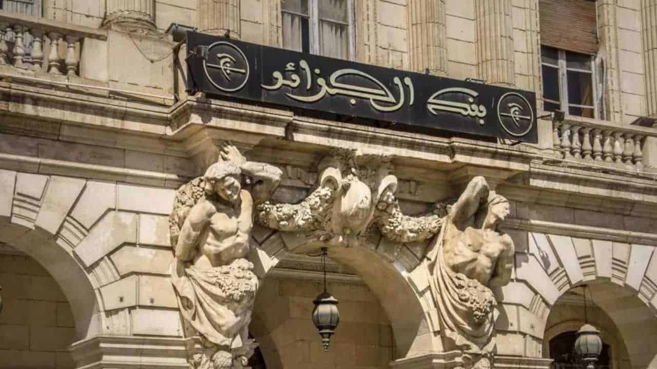 Cash limité en Algérie : découvrez pourquoi la Banque agit Façade d'une banque en Algérie avec sculptures et enseigne.