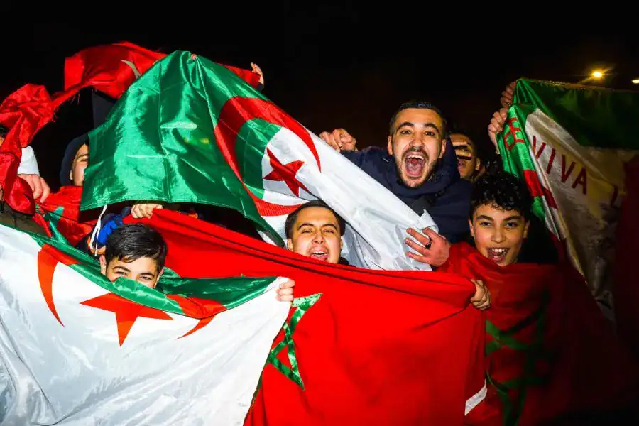 Fête populaire Algérie-Maroc Jeunes fans avec drapeaux algérien et marocain lors d'une célébration.