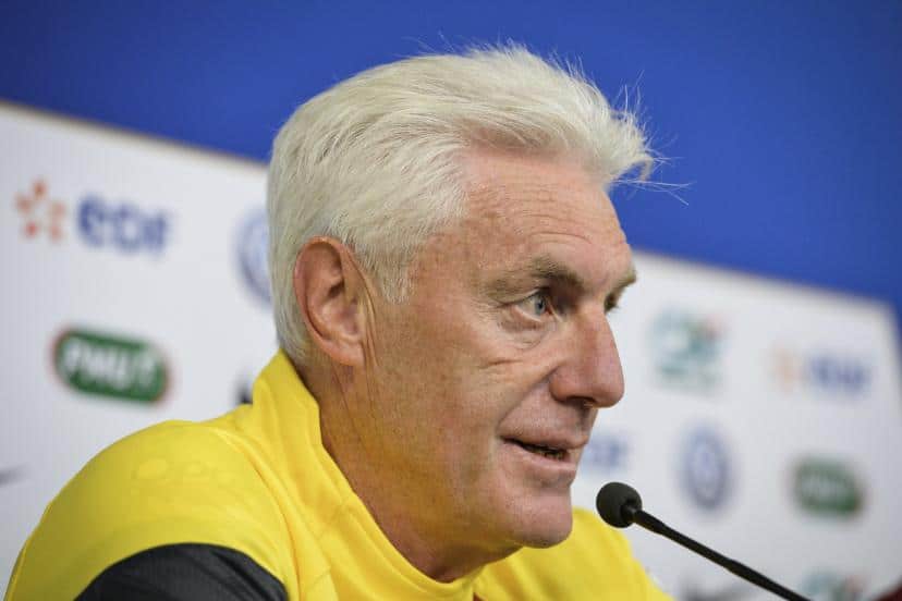Entraîneur de football parlant lors d'une conférence de presse.