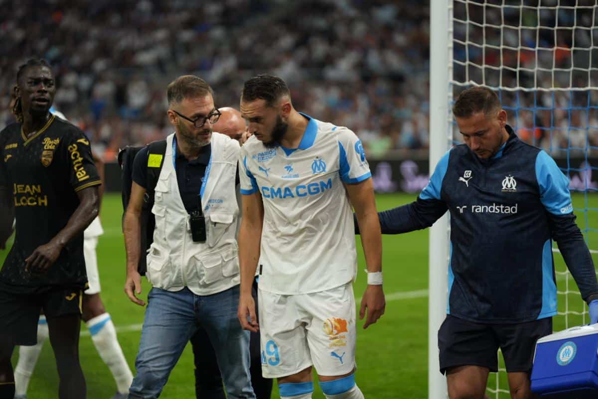 Joueur de Marseille blessé soutenu par l'équipe et le staff médical.
