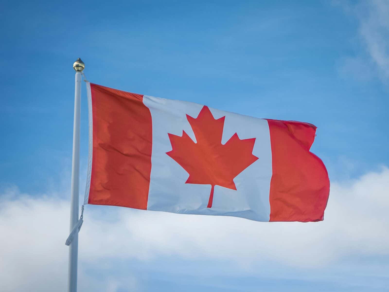 Drapeau du Canada flottant dans le ciel bleu.