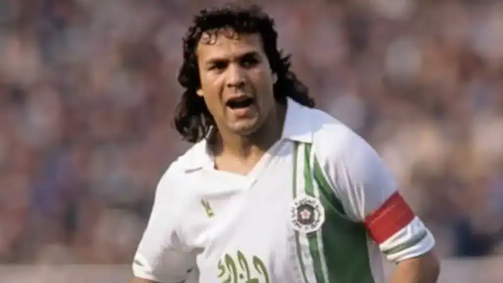 Rabah Madjer en action lors d'un match Rabah Madjer, légende du football algérien, en pleine action sur le terrain.