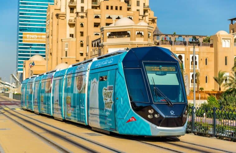Tramway bleu moderne à Alger avec bâtiments en arrière-plan.