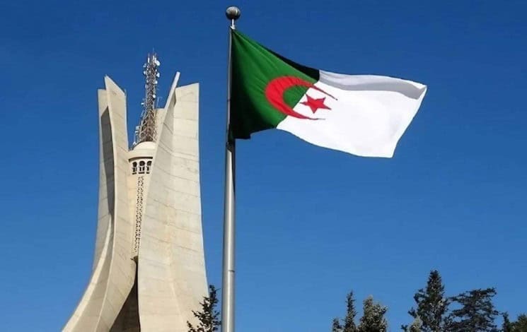Régularisation des Algériens de l’étranger : êtes-vous concerné ? Drapeau national algérien flottant dans le ciel bleu clair.