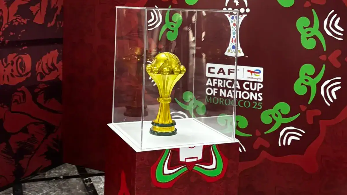 CAN 2025 : le programme inédit des huitièmes de finale dévoilé Trophée de la CAN 2025 exposé dans une vitrine.