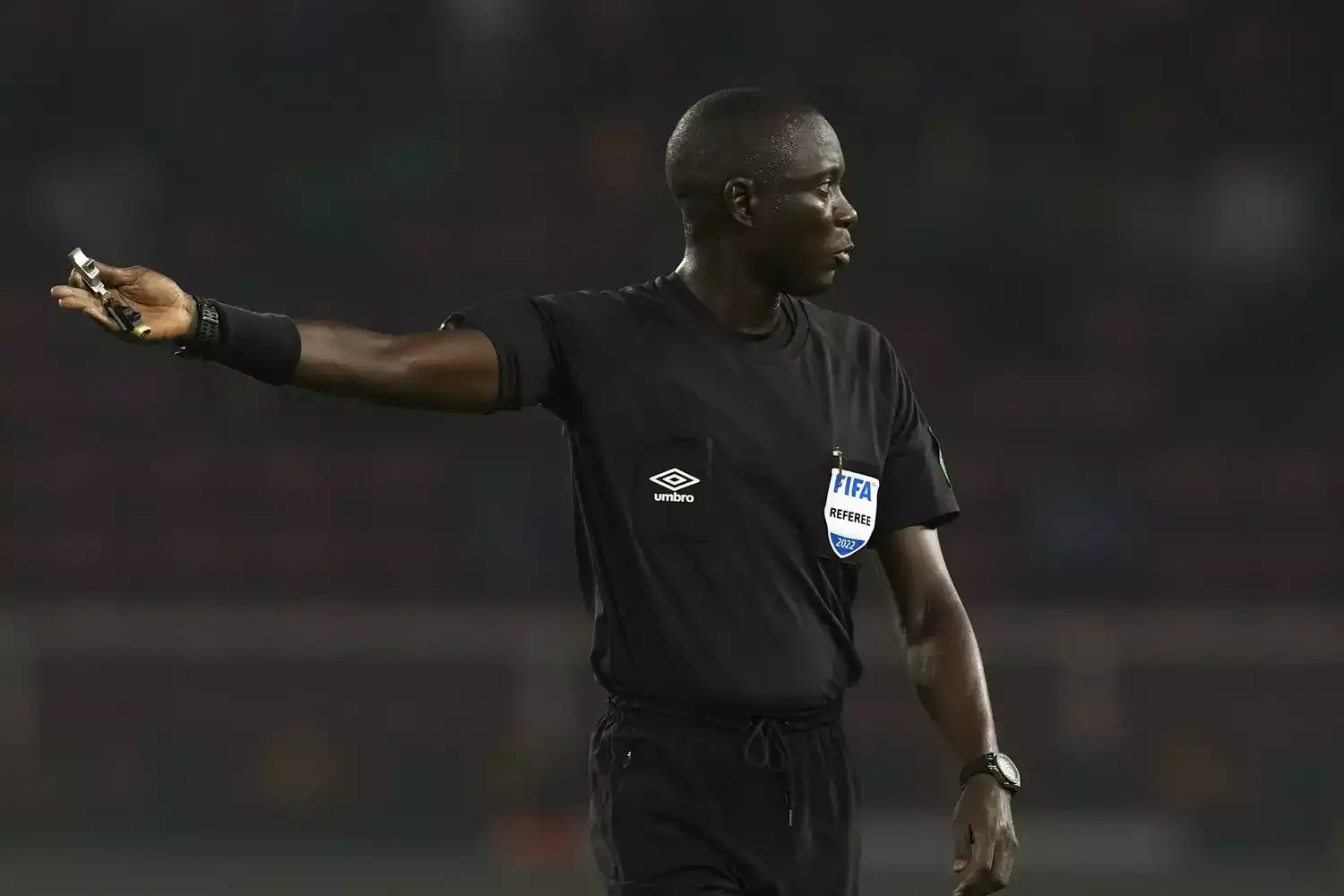 Arbitre de football professionnel en pleine décision sur le terrain.