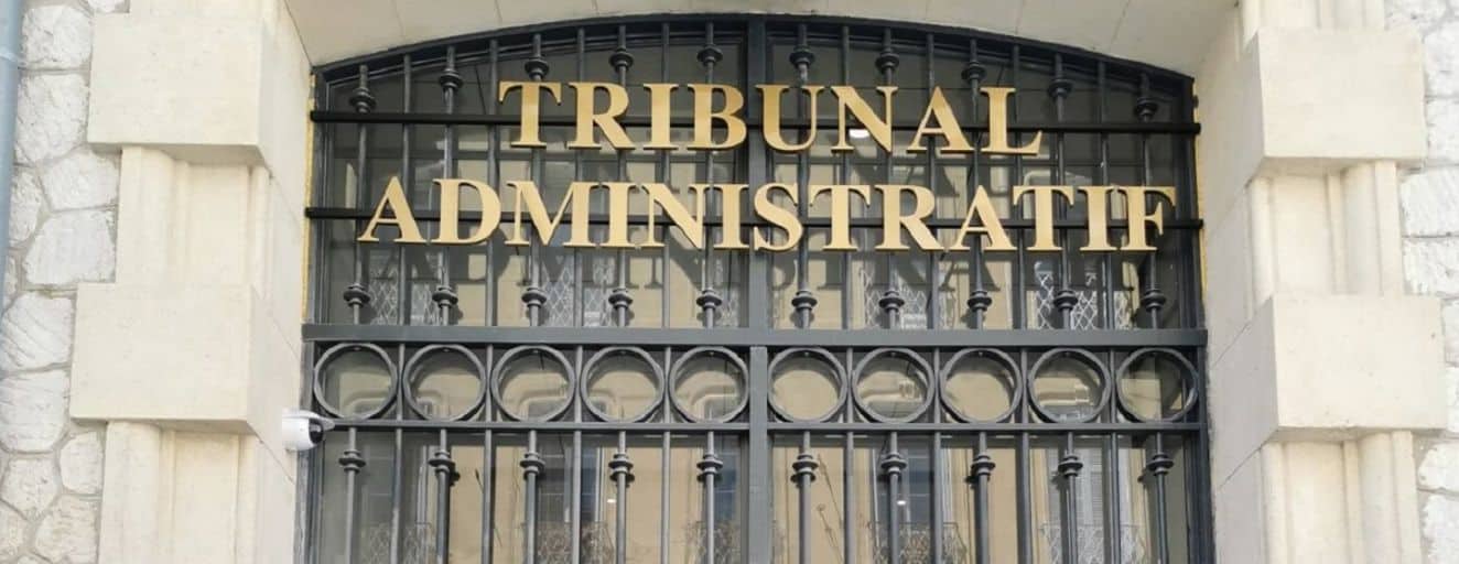 Entrée d'un tribunal administratif en Algérie avec grille en fer forgé.