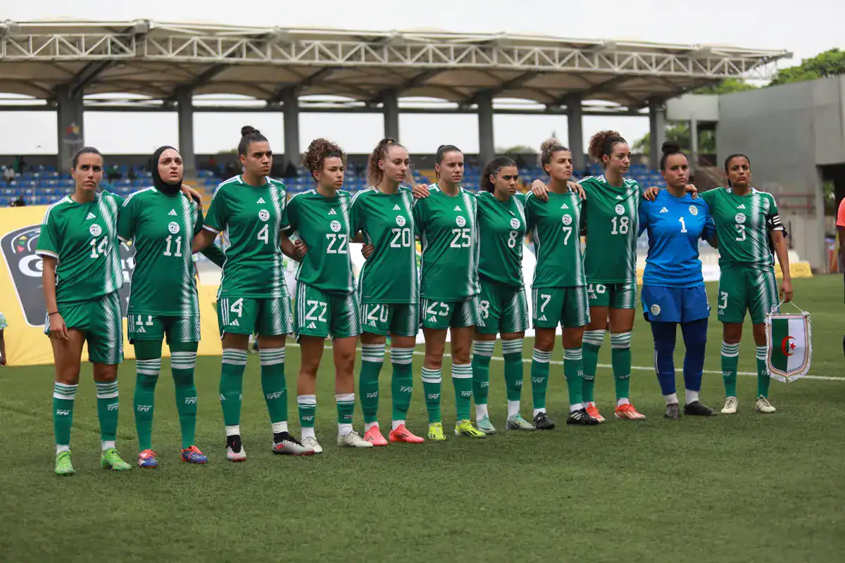 Groupe de joueuses de football algériennes en tenue verte sur le terrain.