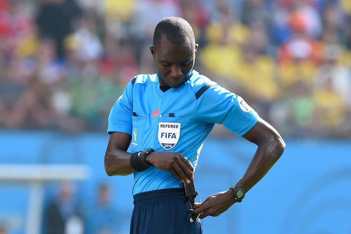 Arbitre de football FIFA en pleine vérification de son équipement.