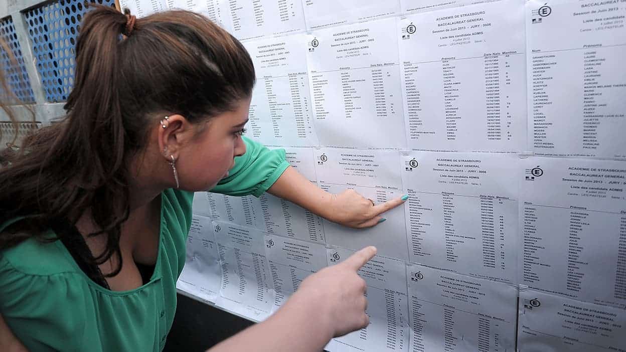 Le bac en Algérie change tout dès cette année : ce qui attend les élèves Étudiante vérifiant ses résultats du bac sur un tableau d'affichage.