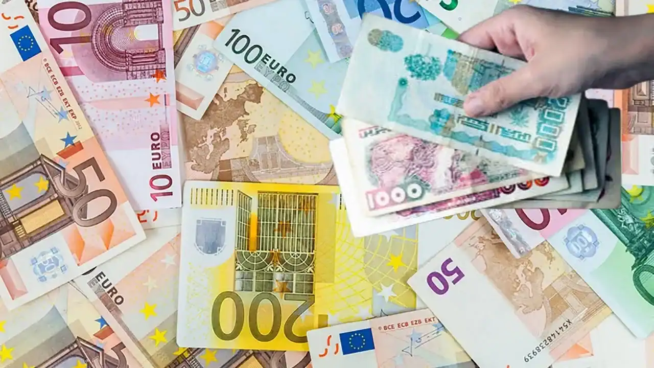 Foule manipulant des billets de banque en euros et dinars algériens.