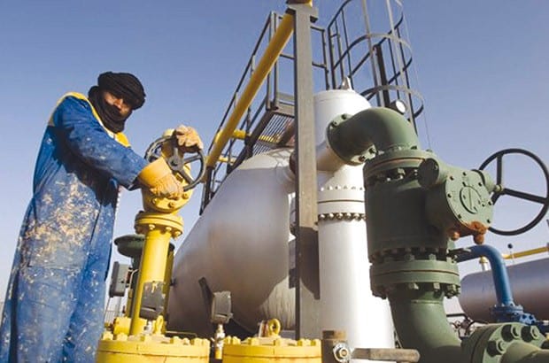 Production pétrolière record en Algérie : un sommet inédit Ingénieur en industrie pétrolière vérifiant l'équipement de forage.