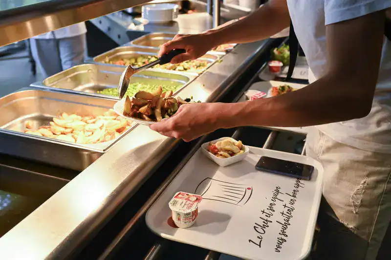Repas étudiant à 1 € : ce qui change dès maintenant en France Étudiant servant un repas dans une cafétéria universitaire en France.