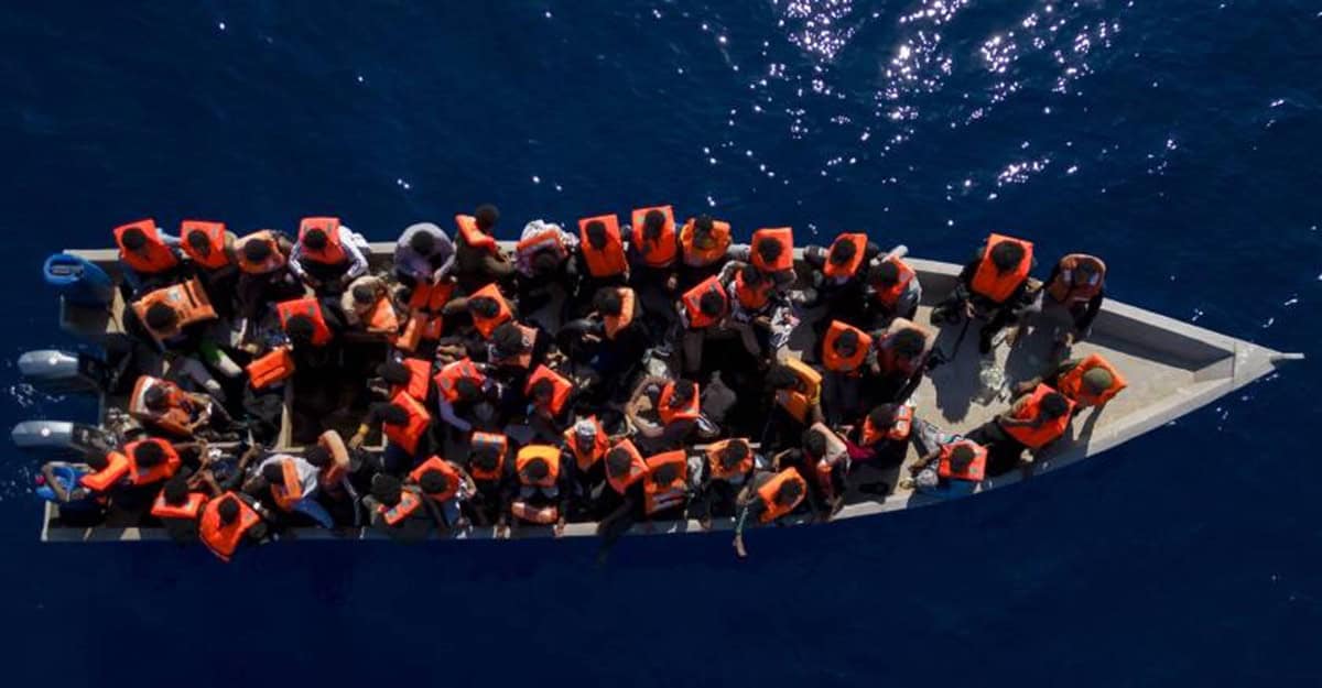 Vers une France à la Trump ? La répression des migrants inquiète Migrants en mer à bord d'une embarcation sur l'océan.