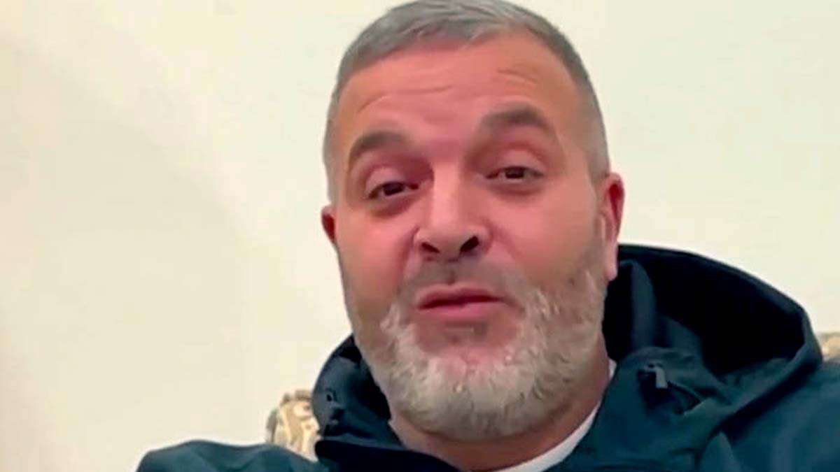Agour Mehenni révèle son lien profond avec l’Algérie Homme avec barbe grise et veste noire, regardant la caméra.