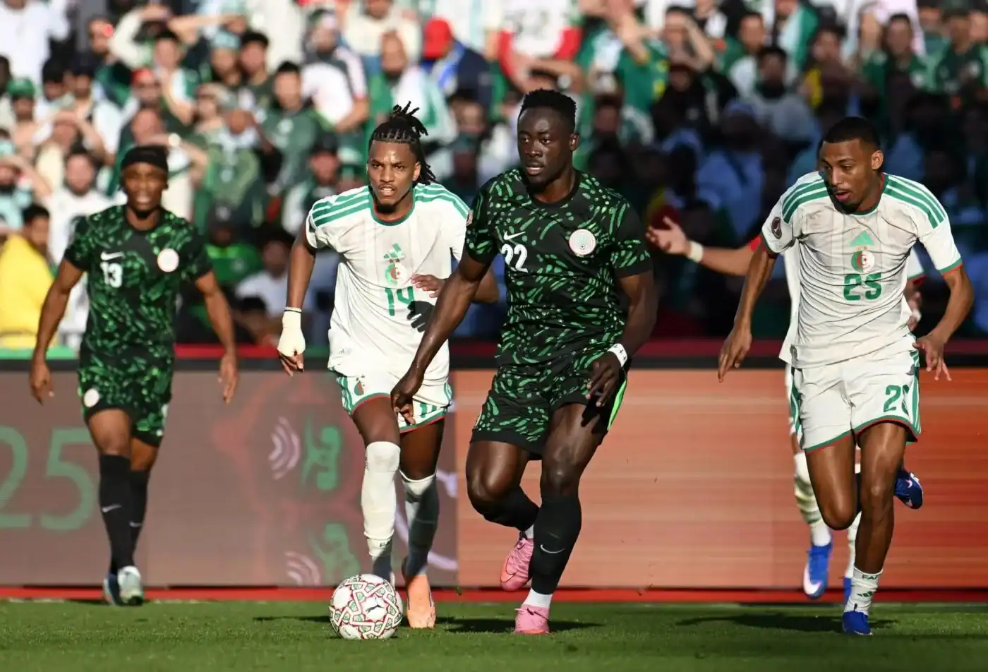 Joueurs de football nigérians et algériens en action lors d'un match.