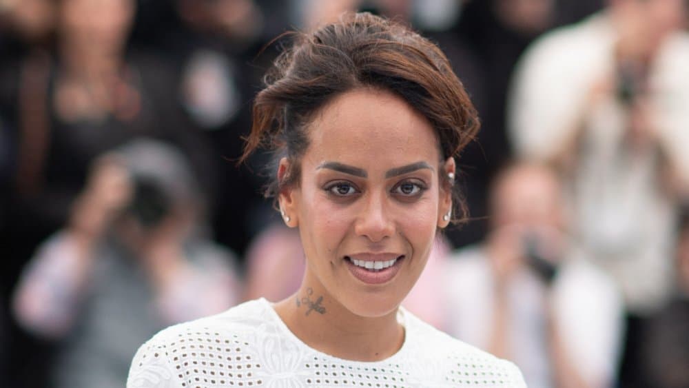 Amel Bent souriante lors d'une manifestation ou événement public.