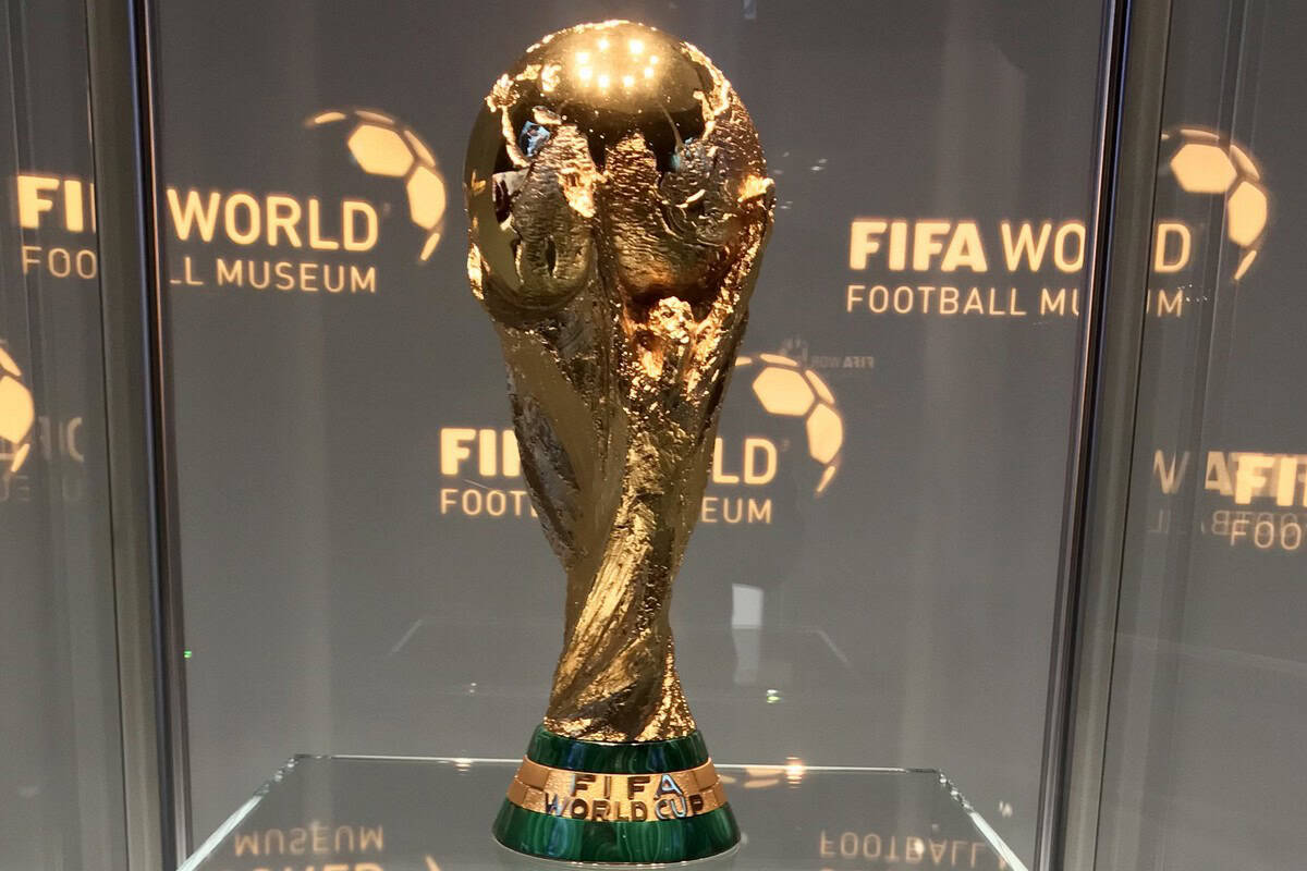 Trophée de la Coupe du Monde FIFA en or dans une vitrine.