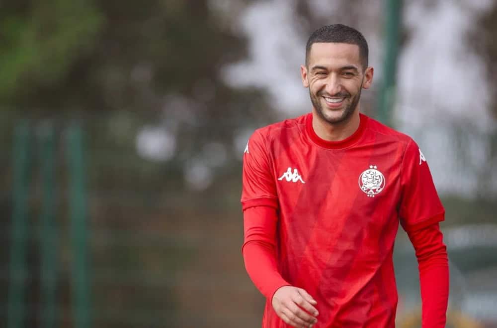 Dérapage de Hakim Ziyech : ce geste enflamme l’Afrique Hakim Ziyech souriant en tenue d'entraînement rouge.