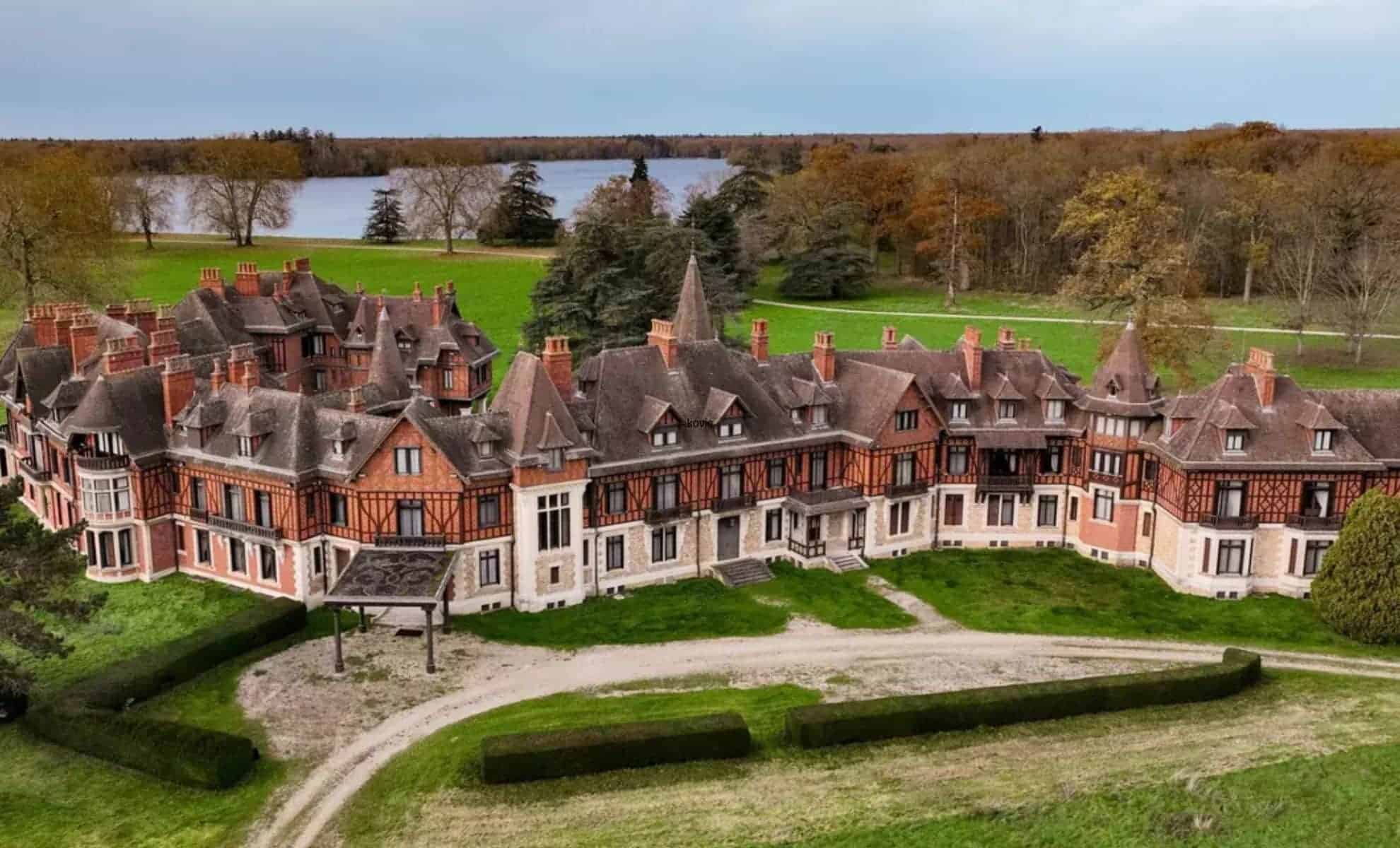 Les luxueuses villas royales marocaines à vendre en France Luxueuse villa royale marocaine avec jardins et lac en arrière-plan.