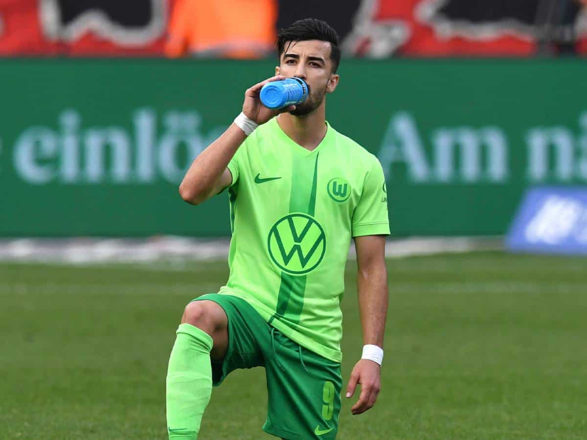 Pourquoi le coach de Amoura a été sanctionné en Allemagne ? Joueur de football en maillot vert buvant de l'eau sur le terrain.