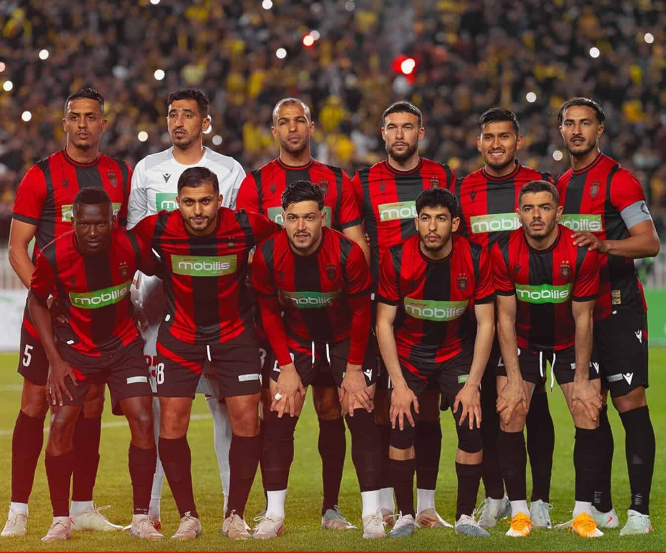 Groupe de joueurs de football en tenue rouge et noire sur le terrain.