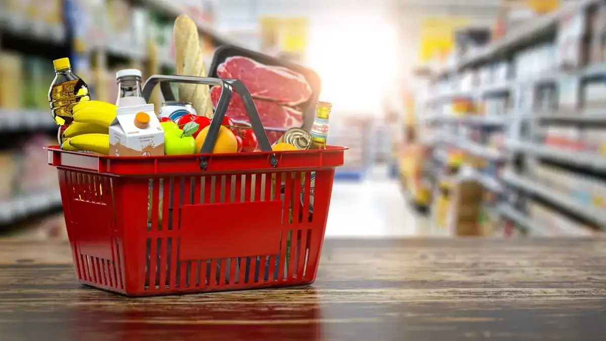 Ramadan 2026 en Algérie : vers des prix stables et sans pénurie Panier d'épicerie avec fruits, légumes et produits alimentaires.