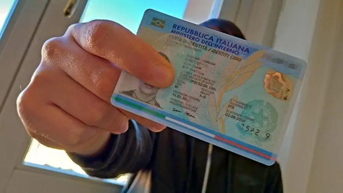 Italie : un nouveau permis unique pour les étrangers ? Personne tenant un permis de conduire italien avec fond clair.