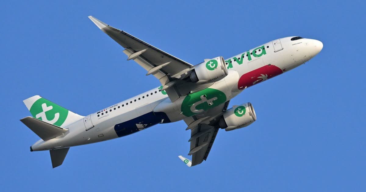 Urgence en vol : un Paris-Alger Transavia rebrousse chemin Avion Transavia avec logo vert en vol dans le ciel bleu.