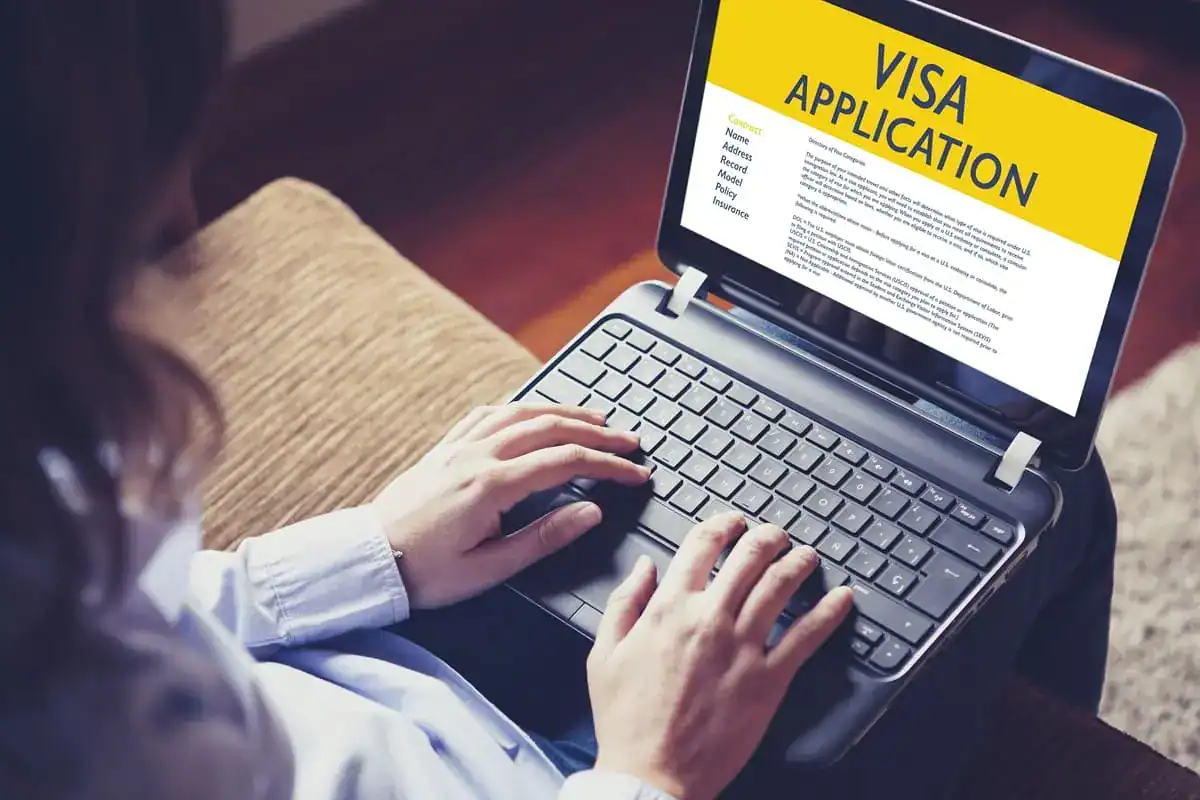 Nouveau e-Visa : une destination s’ouvre aux Algériens Personne utilisant un ordinateur pour remplir une demande de visa en ligne.